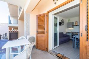 a door leading to a patio with a table and chairs at Appartamento trilocale vista mare FT4 in Cascabraga