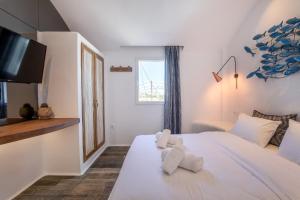 Un dormitorio con una cama blanca con toallas. en KaLanAn Luxury Apartment, en Aggelika