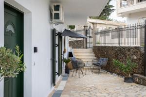 a patio with chairs and a table with an umbrella at Anastasia's House in Kanálion