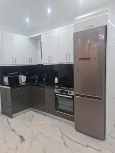 雅典的住宿－Luxury apartment in Attiki，厨房配有不锈钢用具和黑白橱柜
