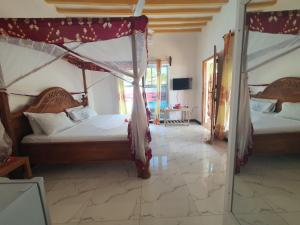 a bedroom with two beds and a mirror at BARIDI VILLA in Kiwengwa +276 photos