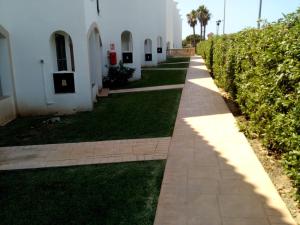 una pasarela frente a un edificio blanco en Calan Blanes con piscina, en Ciutadella