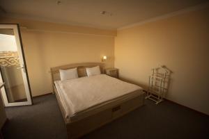 Un dormitorio con una cama y una escalera. en Tashkent Hotel, en Nukus