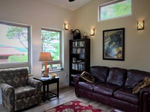 a living room with a leather couch and a chair at Black Bear Inn in Ketchikan