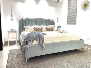 a bedroom with a large bed with a gray headboard at Paradise Room Rialto Residences in Santiago de los Caballeros +42 photos