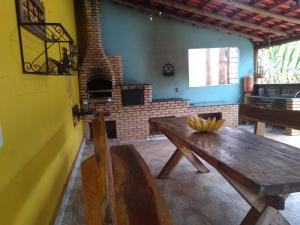 a room with a wooden table and a brick oven at Sítio Descanso E Natureza Igarapé - 20km Inhotim in Igarapé