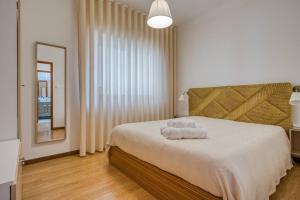 ein Schlafzimmer mit einem Bett mit zwei Handtüchern darauf in der Unterkunft Spacious House in Porto for family and friends in Maia