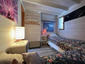 1 dormitorio con 2 camas y mesa con lámpara en Chalet authentique, en La Salette-Fallavaux