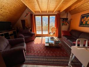 a living room with a couch and a table at Chalet Vue Montagne 6 personnes proche Sanctuaire de La Salette in La Salette-Fallavaux