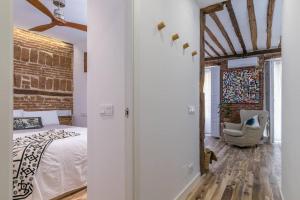 マドリードにあるBonito apartamento en típica corrala en el centro de Madridのレンガの壁、ベッド付きのベッドルーム1室