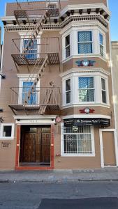 a large pink building with a balcony and a door at European Hostel in San Francisco