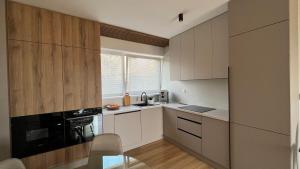 a kitchen with white cabinets and a black appliance at Rezidencia pod Zámkom Bojnice Apartmán Luna in Bojnice