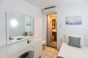a white room with a mirror and a bed at Achilleas Pension in Hydra