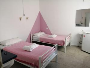 a room with two beds with pink sheets and a mirror at Coordenadas Ibiza in Ibiza Town