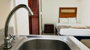 a bathroom with a sink and a bedroom with a bed at Hotel B&B - 5th Avenue in Playa del Carmen +101 photos