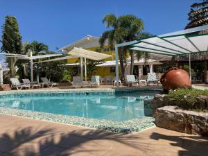 uma piscina com cadeiras e um edifício em HOTEL CASA AMARILLA et RESTAURANT em Punta Chame