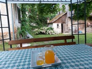 um frasco de vidro de sumo de laranja num prato numa mesa em Domačija pri Ivankovih em Osilnica