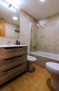 a bathroom with a sink and a toilet and a tub at Apartamento Aregoma in Puerto del Rosario