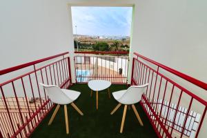 a balcony with two white chairs and a view at Apartamento Aregoma in Puerto del Rosario