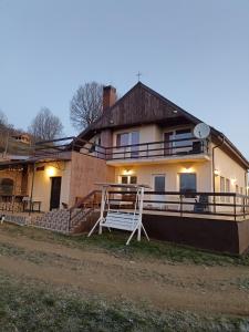 ein großes Haus mit einer Veranda und einem Haus in der Unterkunft Cabana Refugiu Montan in Băişoara