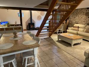 een woonkamer met een tafel en een bank bij Rustic and spacious converted Barn in Isigny-le-Buat