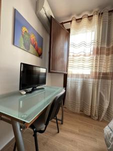 a desk with a computer in a room with a window at Mareblu B&B in Cefalù