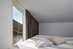 a bedroom with a bed and a large window at Apartman Damjan in Pješčana Uvala