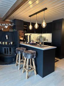 a kitchen with a counter and stools in a room at Lekker hytte nær sentrum in Beitostøl