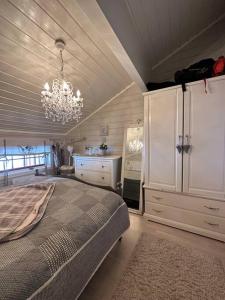 um quarto com uma cama grande e um lustre em Lekker hytte nær sentrum em Beitostøl