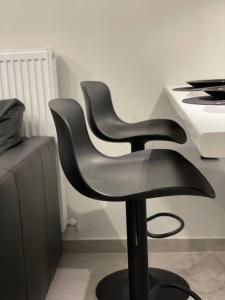 zwei schwarze Stühle neben einem Schreibtisch in der Unterkunft Elite Suite with private parking in Kavala