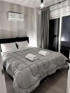 ein Schlafzimmer mit einem großen Bett mit zwei Handtüchern darauf in der Unterkunft Elite Suite with private parking in Kavala