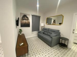 uma sala de estar com um sofá e um espelho em Estudio El Soportal de la Plaza em Daimiel
