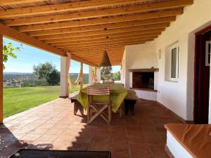 eine Terrasse mit einem Tisch und einem Kamin in der Unterkunft Monte da Casa Nova - Jul and Ago only 7 days stays check-in and check-out on Saturdays in Vale de Água