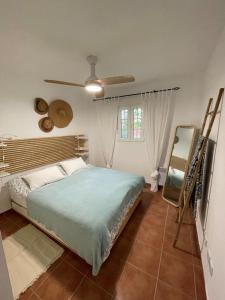 1 dormitorio con 1 cama y ventilador de techo en Charming apartment, golf, kitesurfing, free tennis courts and bikes, en Isla Canela
