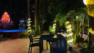 einen Tisch und Stühle in einem Garten mit Beleuchtung in der Unterkunft Hotel B&B - 5th Avenue in Playa del Carmen