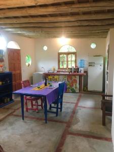 cocina con mesa púrpura y nevera en Casa de montaña placentera en la naturaleza con vista espectacular en Traslasierra en Córdoba