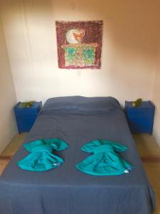 Una cama con sábanas azules en una habitación en Casa de montaña placentera en la naturaleza con vista espectacular en Traslasierra en Córdoba