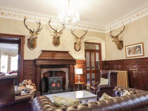 a living room with a fireplace and antlers on the wall at Ledgowan Lodge Hotel in Achnasheen