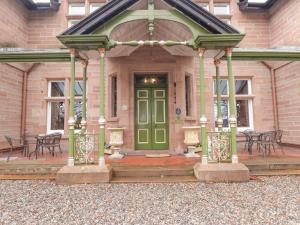 a green door on the front of a building at Ledgowan Lodge Hotel in Achnasheen