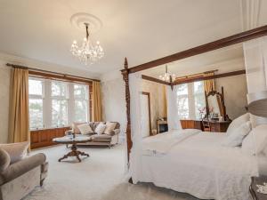 Un dormitorio con una cama grande y una lámpara de araña. en Ledgowan Lodge Hotel, en Achnasheen