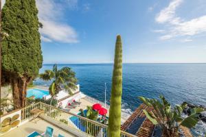 a view of the ocean from a resort with a palm tree at Villa Beach Club in Santa Cruz