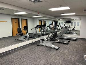 a gym with several treadmills and elliptical machines at Greenlight Inn & Suites St James in Saint James