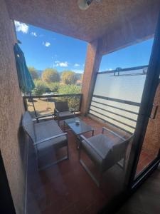 widok na balkon z krzesłami i stołem w obiekcie Studio pied dans l'eau - WIFI- Piscine w mieście Santa-Lucia-di-Moriani