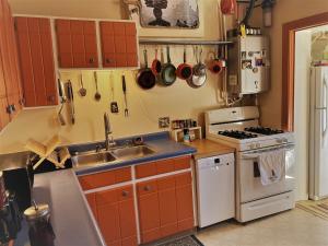 a kitchen with orange cabinets and a sink and a stove at La Casita Colorada, 12 Block To River Str#865 in Salida