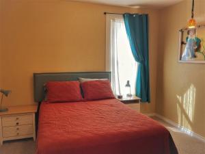 a bedroom with a bed with red sheets and a window at La Casita Colorada, 12 Block To River Str#865 in Salida