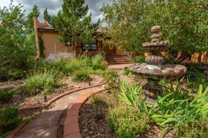a garden with a fountain in front of a house at Vista Grande 1 Mi To Salida 3 Or 4 Bdrm Options in Salida