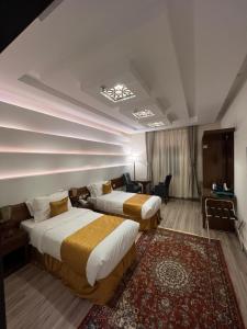 a hotel room with two beds and a rug at فندق الليالي الحالمة in Al Madinah