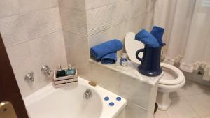 uma casa de banho com um WC e uma banheira com toalhas azuis em Casa Giovanna em Venturina Terme