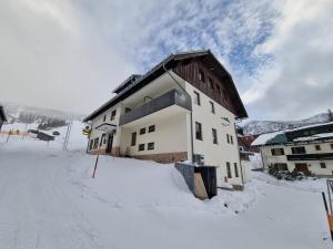 een gebouw in de sneeuw met een besneeuwde weg bij Hotel PlannerInn in Planneralm