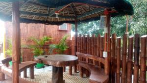 a wooden bench with a table and an umbrella at Villa Lenda Resort - San Manuel, Pangasinan 